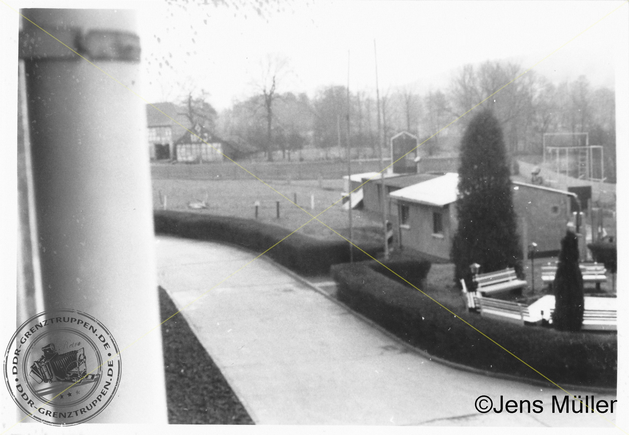 Aufnahme zeigt Hundezwinger Anlage, im Hintergrund der Sportplatz mit Sturmbahn und den Bereich der Grenzsäule mit Bänken und Brunnen. 